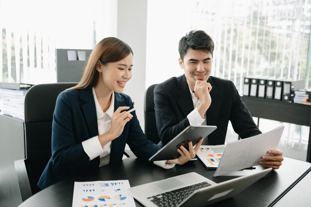 Foto dois trabalhadores de negócios falando no smartphone e usando laptop no escritório moderno