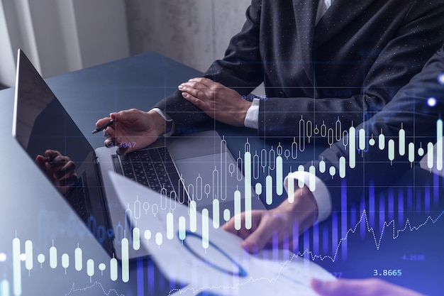 Dois traders pesquisando dados históricos para prever o comportamento do mercado de ações usando o conceito de negociação na Internet de laptop Forex e gráfico de holograma financeiro Previsão e planejamento