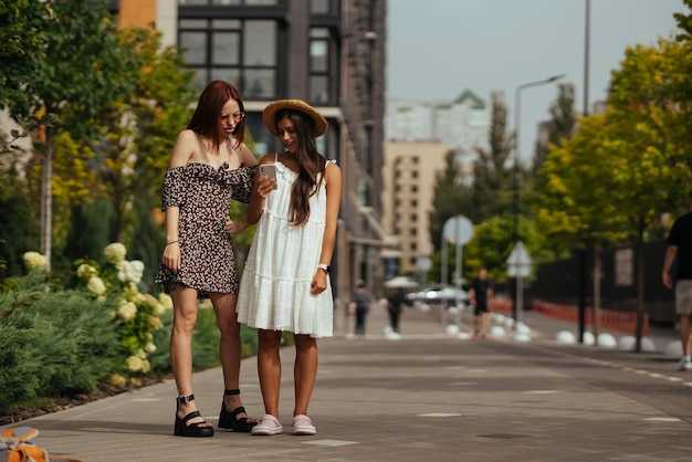 Dois turistas felizes com um telefone em uma rua da cidade