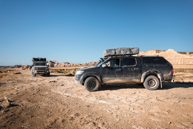 Dois veículos 4x4 em uma paisagem desértica em Bardenas Reales, Navarra, País Basco.