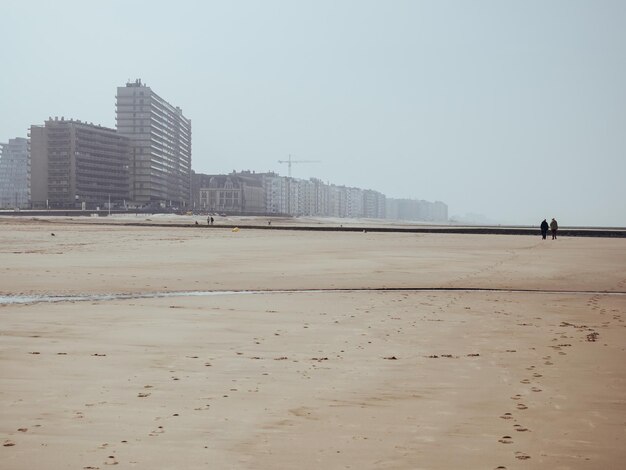 Foto dois velhos a caminhar na praia.