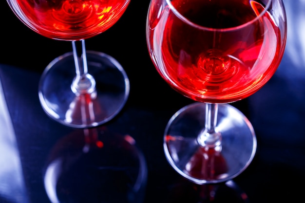 Dois vidros do vinho vermelho no clube de noite com reflexão. Beba relaxe o conceito.