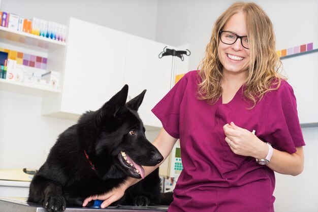 Doktor an der Veterinärklinik, die mit einem schönen Hund lächelt