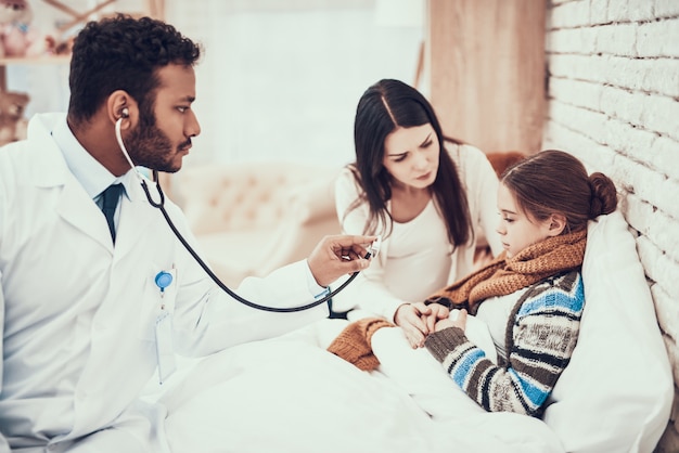 Doktor benutzt Stethoskop. Schwangere Mutter und Tochter.