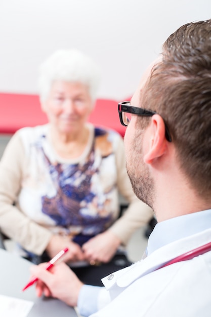 Doktor, der älteren Patienten in der Praxis sieht