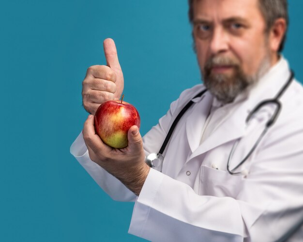 Doktor, der Apfel für gesunde Ernährung gibt