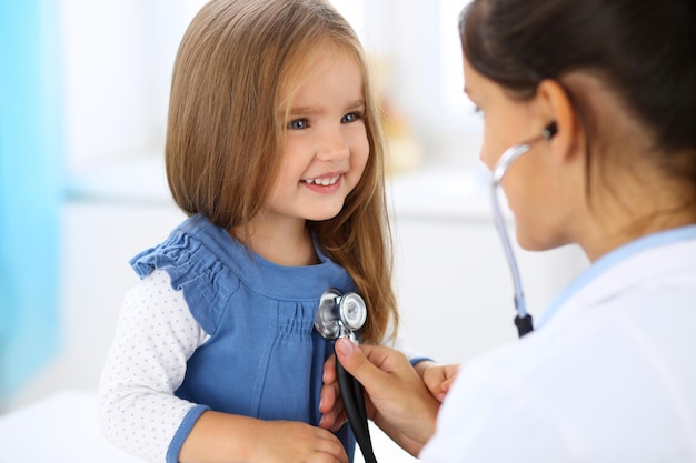 Foto doktor, der ein kleines mädchen durch stethoskop untersucht