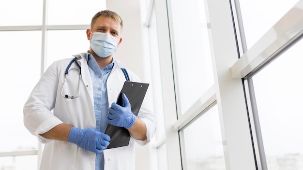 Foto doktor, der eine gesichtsmaske und op-handschuhe trägt