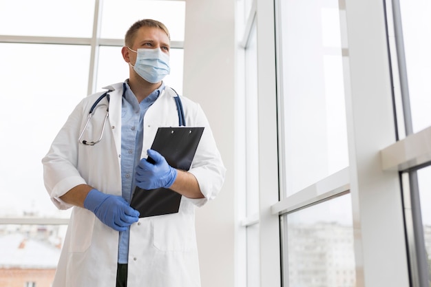 Foto doktor, der eine gesichtsmaske und op-handschuhe trägt