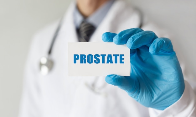 Doktor, der eine Karte mit Text PROSTATE, medizinisches Konzept hält