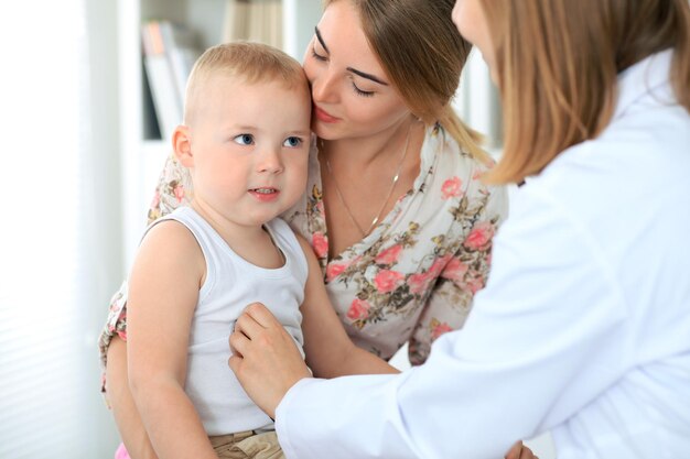 Doktor, der einen Kinderpatienten durch Stethoskop überprüft