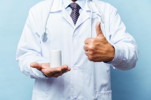 Doktor, der Flasche Pillen auf weißem Hintergrund hält. Das Konzept von Medizin, Pharmakologie, Gesundheitswesen
