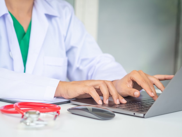 Doktor, der mit Laptop-Computer in ihrem Büro arbeitet