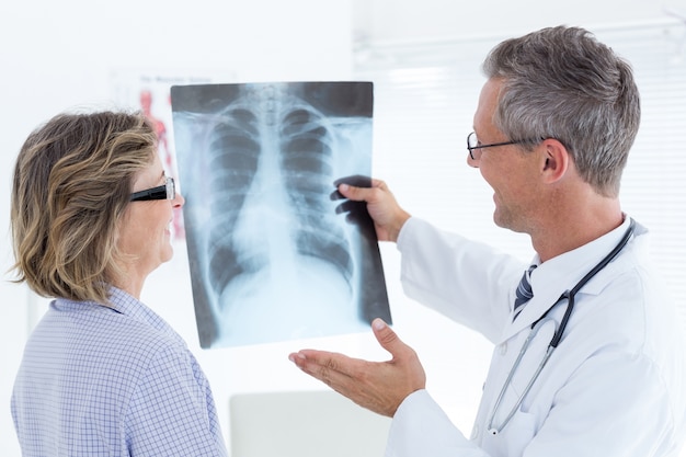 Foto doktor, der seinem patienten röntgenstrahl zeigt