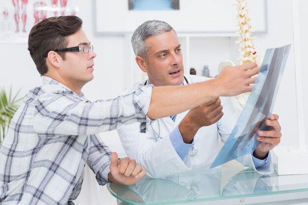 Foto doktor, der seinem patienten röntgenstrahlen zeigt