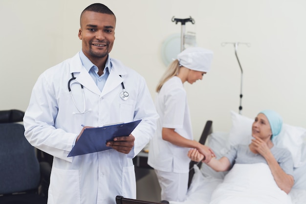 Doktor, der vor dem hintergrund des Patienten aufwirft.