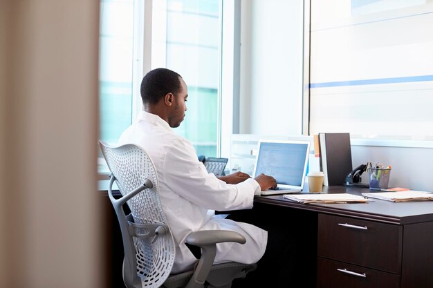 Doktor, Der Weißen Kittel Trägt, Der Am Laptop Im Büro Arbeitet