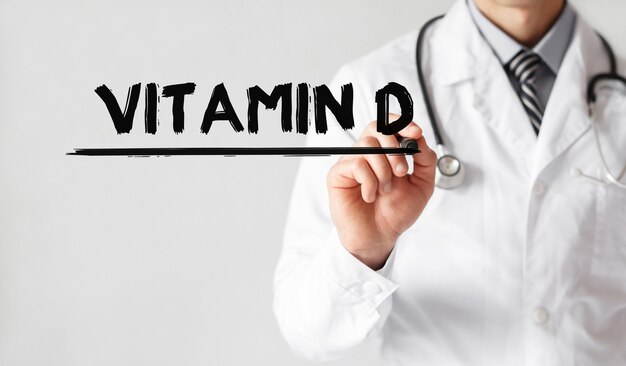 Doktor, der Wort VITAMIN D mit Marker, medizinisches Konzept schreibt