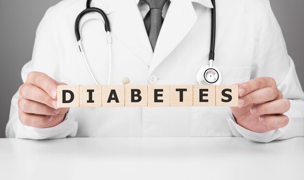Doktor hält Holzwürfel in seinen Händen mit Text Diabetes