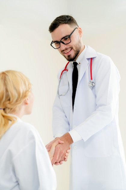 Doktor im Krankenhaus rüttelt Hand mit einem anderen Doktor