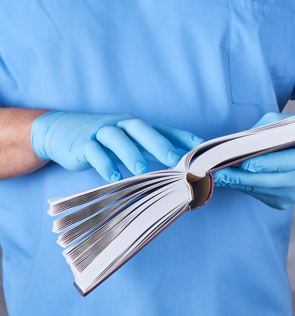 Doktor in der blauen Uniform hält ein offenes Buch in seinen Händen