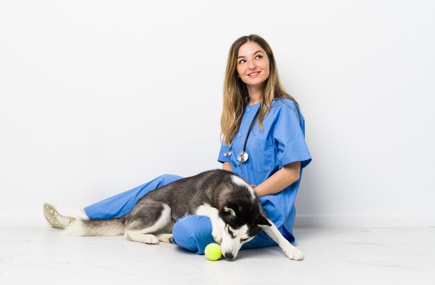 Doktor mit ihrem Hund sitzt auf dem Boden