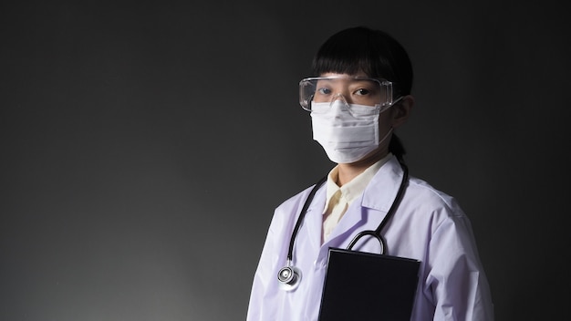 Doktor mit medizinischer Maske und klarer Schutzbrille oder Brille und Stethoskop am Hals und weißer Uniform.