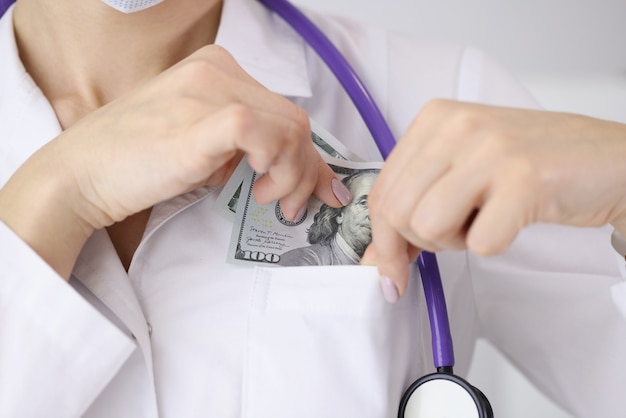 Doktor steckt Hundert-Dollar-Schein in seine Tasche