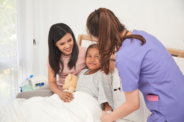 Doktor und Kind mit Mutter im Krankenhaus