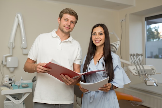 Doktor und sein Assistent, die im Ordner mit Papier schauen