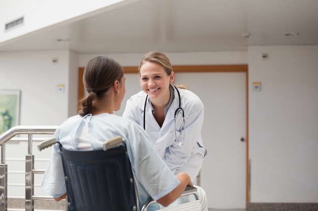 Doktor vor einem Patienten auf einem Rollstuhl