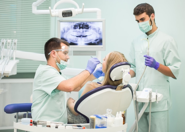 Doktor Zahnarzt mit einem Assistenten arbeiten in einer Zahnklinik.