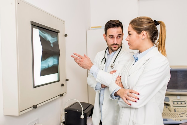 Doktoren, die einen Röntgenstrahl des Patienten an der Klinik überprüfen