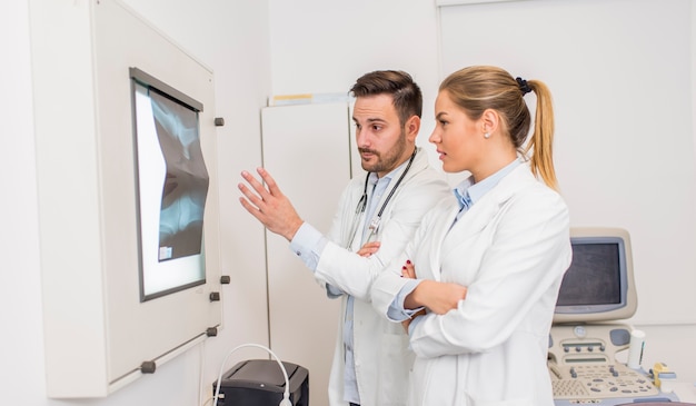 Foto doktoren, die einen röntgenstrahl des patienten an der klinik überprüfen