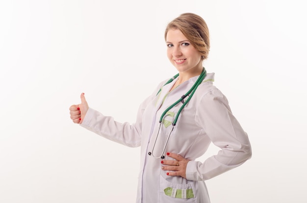 Doktorfrau auf dem weißen Hintergrund, der Daumen zeigt