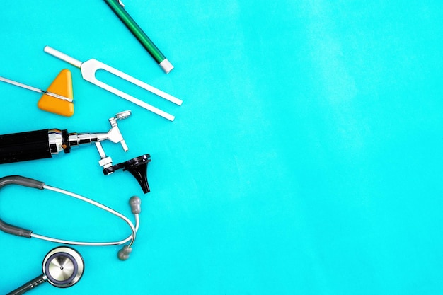 Doktorwerkzeuge tuning forkflash lighthammer jerkotoscope und stethoskop auf grünem chirurgischem hintergrund mit kopienraum