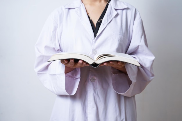 Doktorwissenschaftler in einem weißen Mantel, der ein offenes Buch hält. Wissen, Lernen, Studienkonzept.