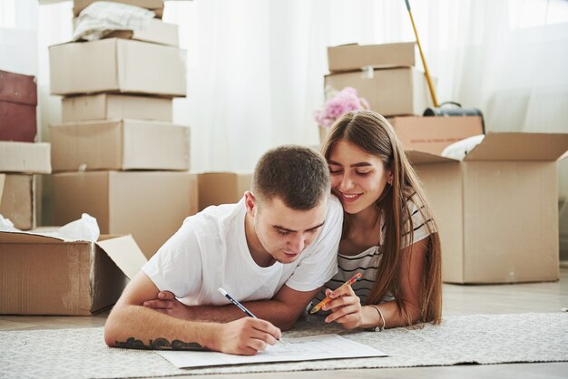 Dokument einreichen. Fröhliches junges Paar in ihrer neuen Wohnung. Konzeption des Umzugs.