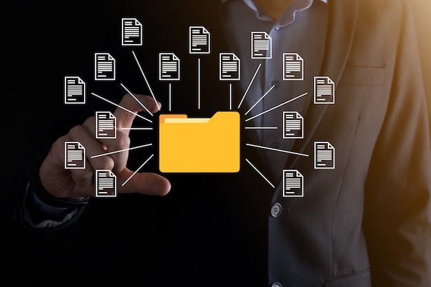 Dokumentenmanagementsystem DMS. Geschäftsmann hält Ordner- und Dokumentsymbol. Software zum Archivieren, Suchen und Verwalten von Unternehmensdateien und -informationen. Internet-Technologiekonzept. Digitale Sicherheit.