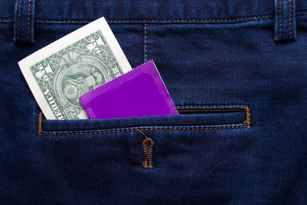 Dólar estadounidense y condón en el bolsillo de los jeans azules Protéjase Use un condón