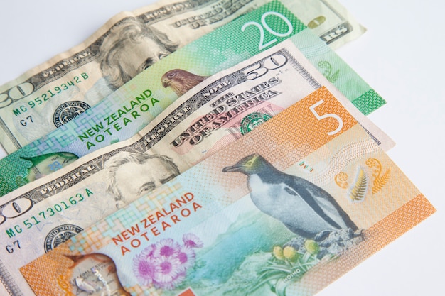 Dólar estadounidense y dólar de Nueva Zelanda sobre fondo blanco divisas