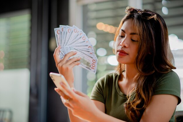 Foto dólar moneda finanzas e inversiones mujer joven feliz con el dinero y los salarios del trabajo ingresos en efectivo