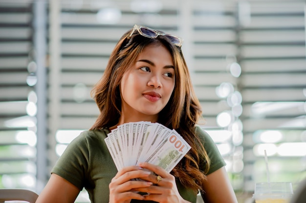 Foto dólar moneda finanzas e inversiones mujer joven feliz con el dinero y los salarios del trabajo ingresos en efectivo