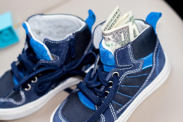 Foto un dólar en zapatos azules para niños en el interior de un auto moderno dinero como regalo