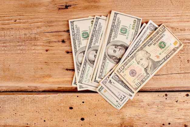 Dólares americanos em close-up de fundo de madeira com espaço de cópia. Negócios e Finanças.