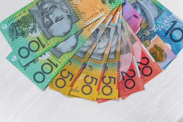 Dólares australianos coloridos na mesa de madeira