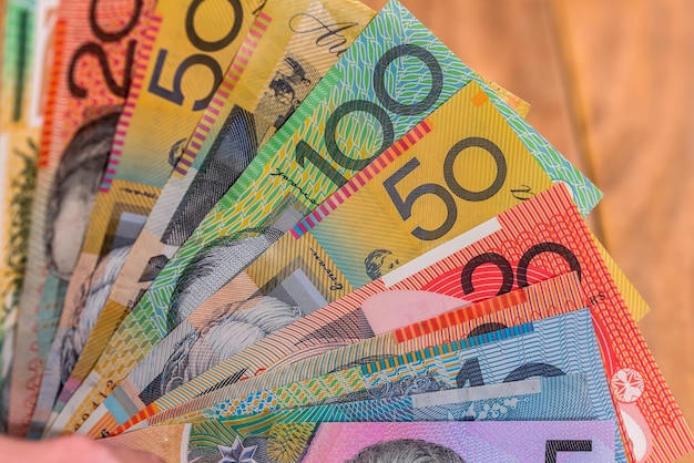 Dólares australianos em leque em mesa de madeira