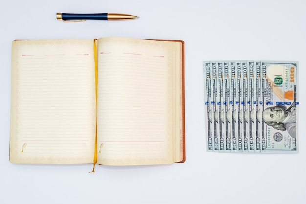 Dólares cuaderno y bolígrafo con fondo blanco aislado