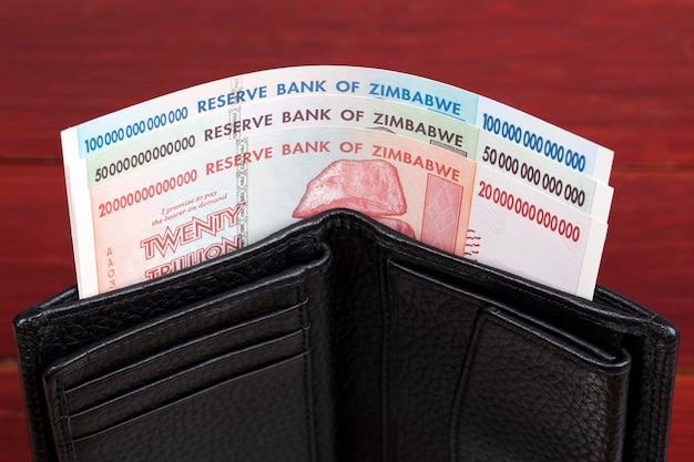 Dólares velhos das cédulas do Zimbábue na carteira preta x9