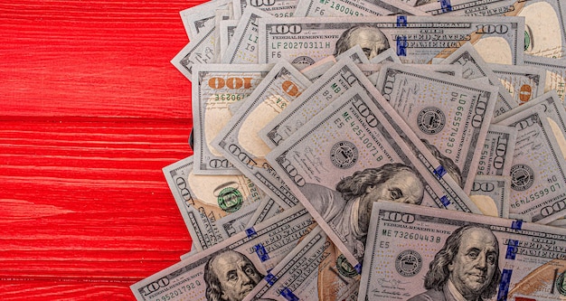 Foto dollar auf rotem hintergrund aus holz geld auf dem tisch us-dollar